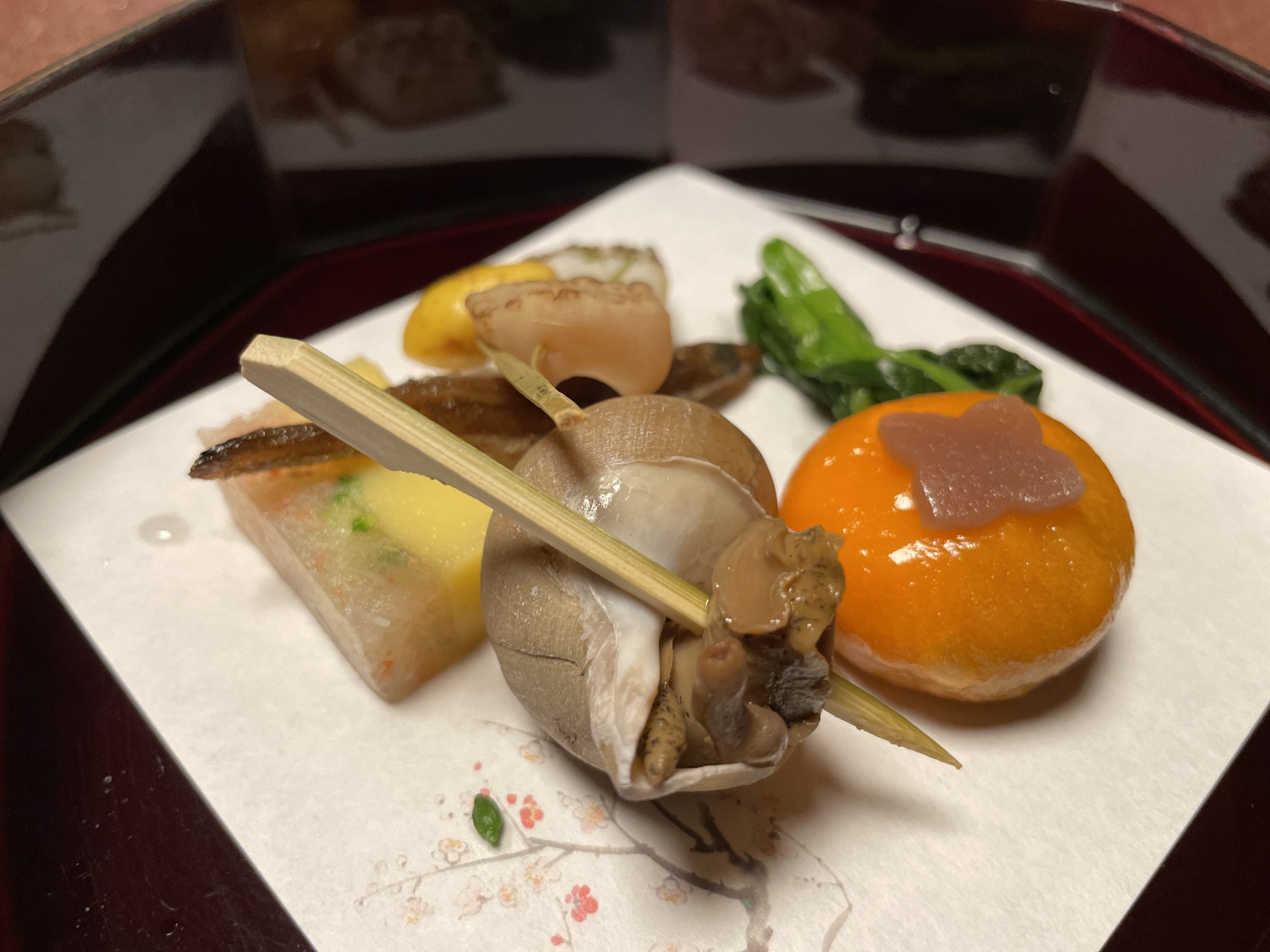 The opening plate: whelk, a mochi shaped like a seasonal fruit, and other small bites.