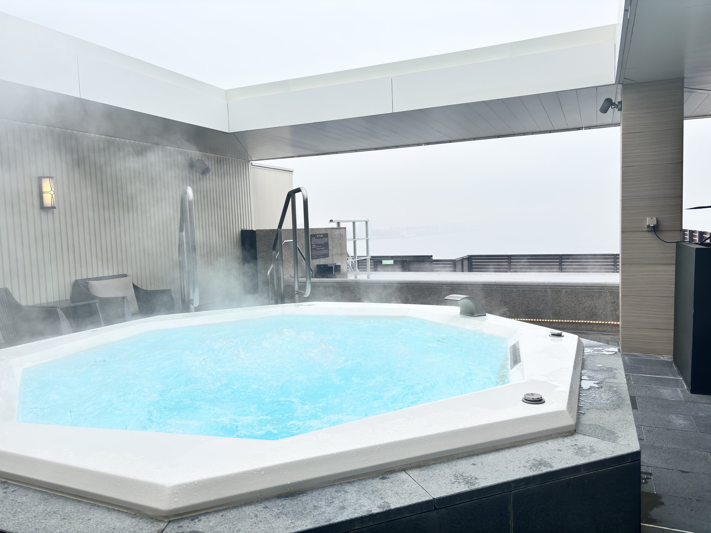 The outdoor jacuzzi, steaming against a gray sky.