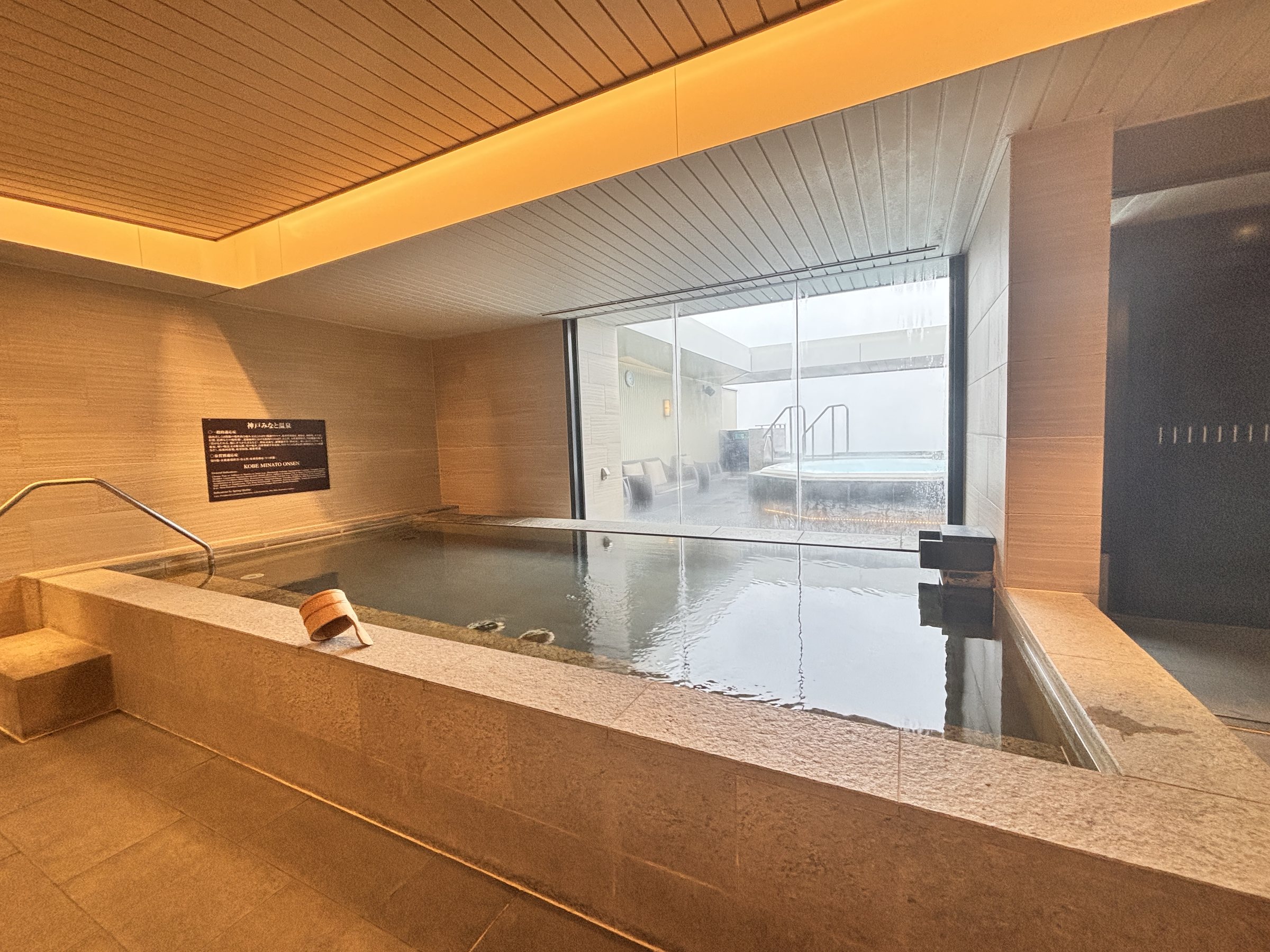 A large indoor hot-spring bath with windows onto the deck.