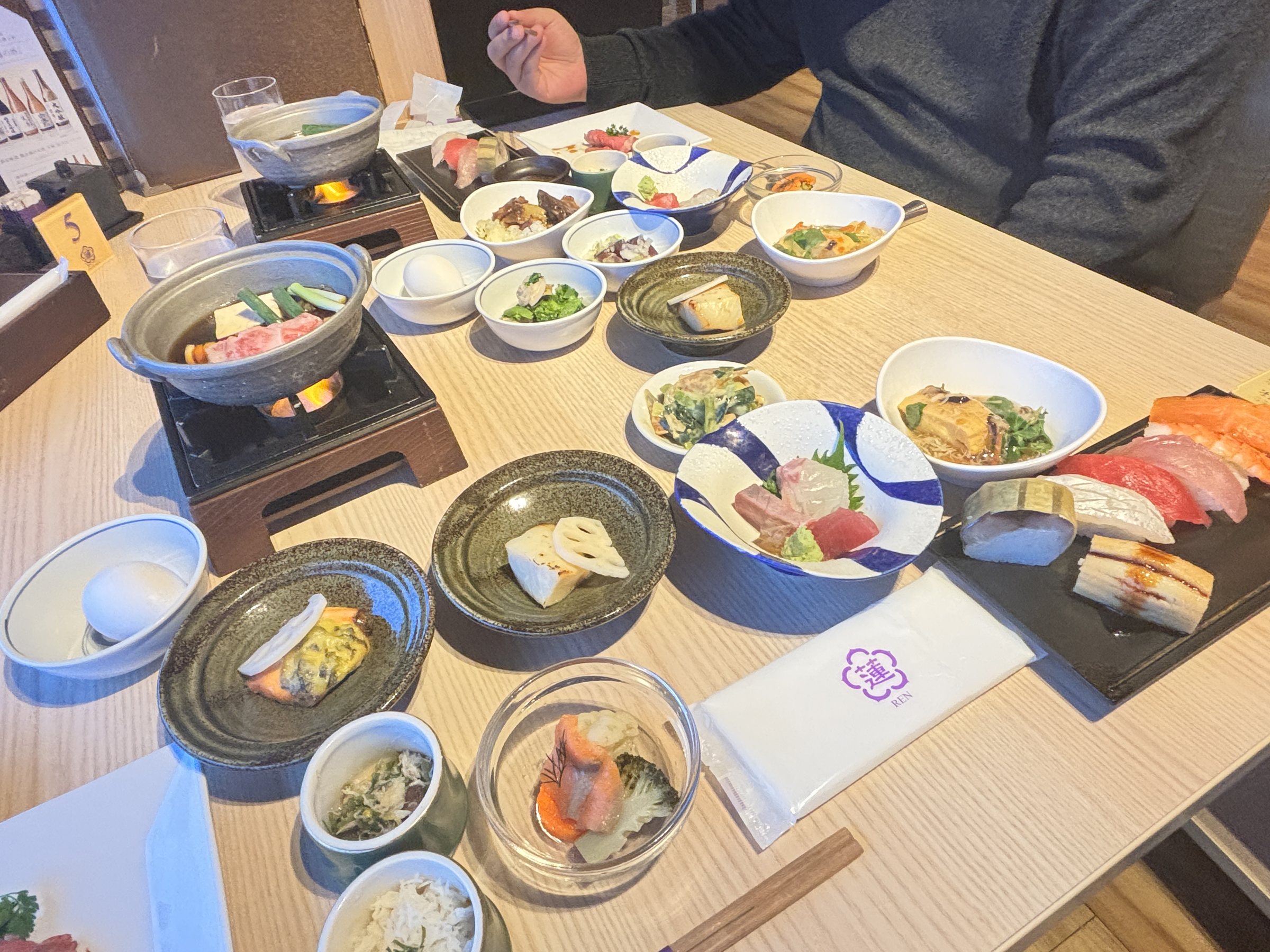 A second spread from the buffet, with sushi, small bowls and a hotpot.