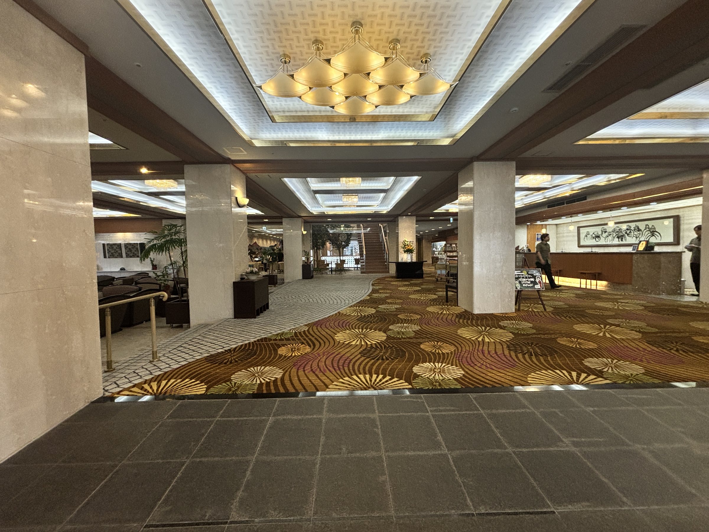 The entrance hall, with its patterned carpet and chandeliers.
