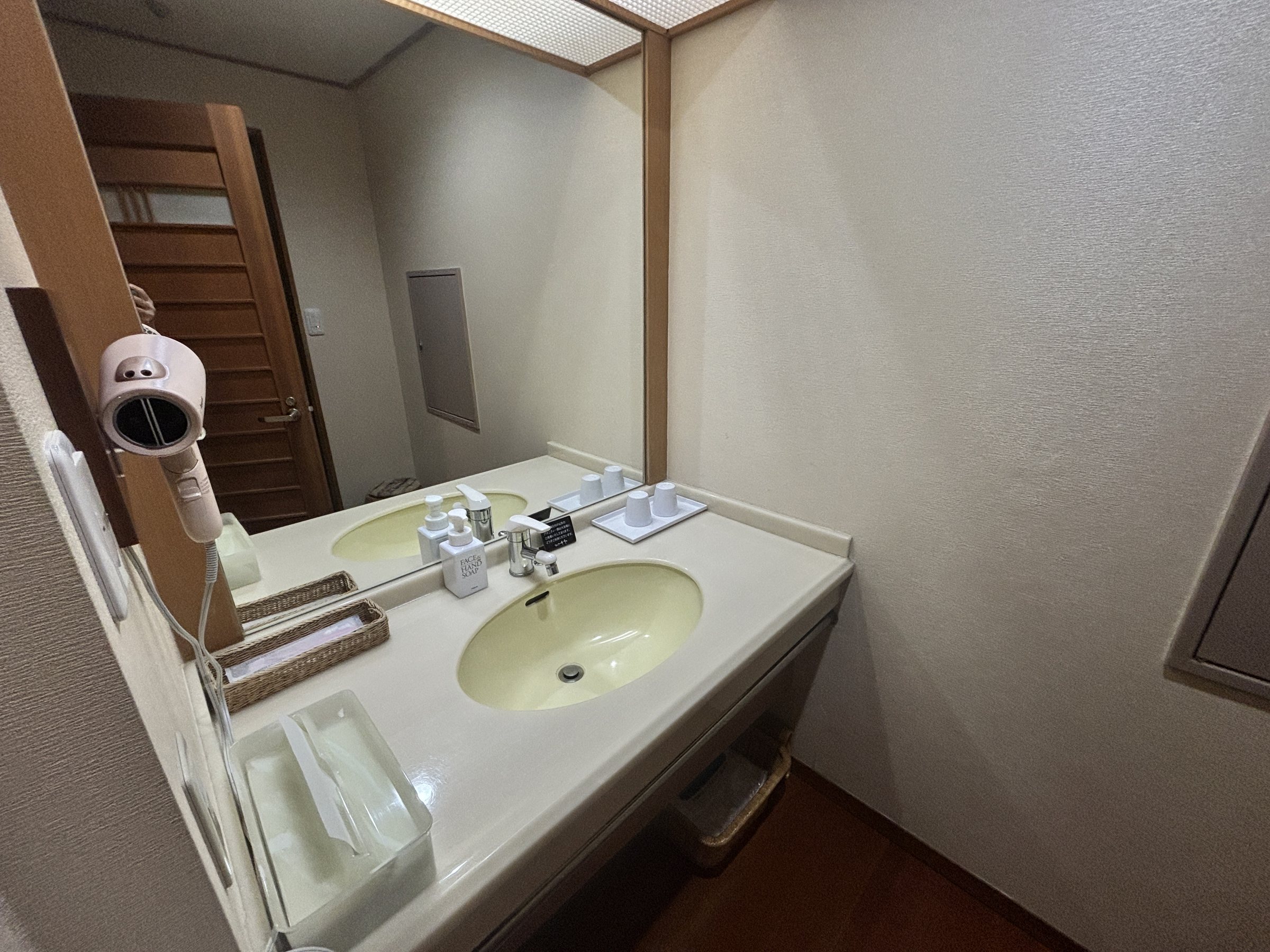 A washbasin with a hairdryer and toiletries.