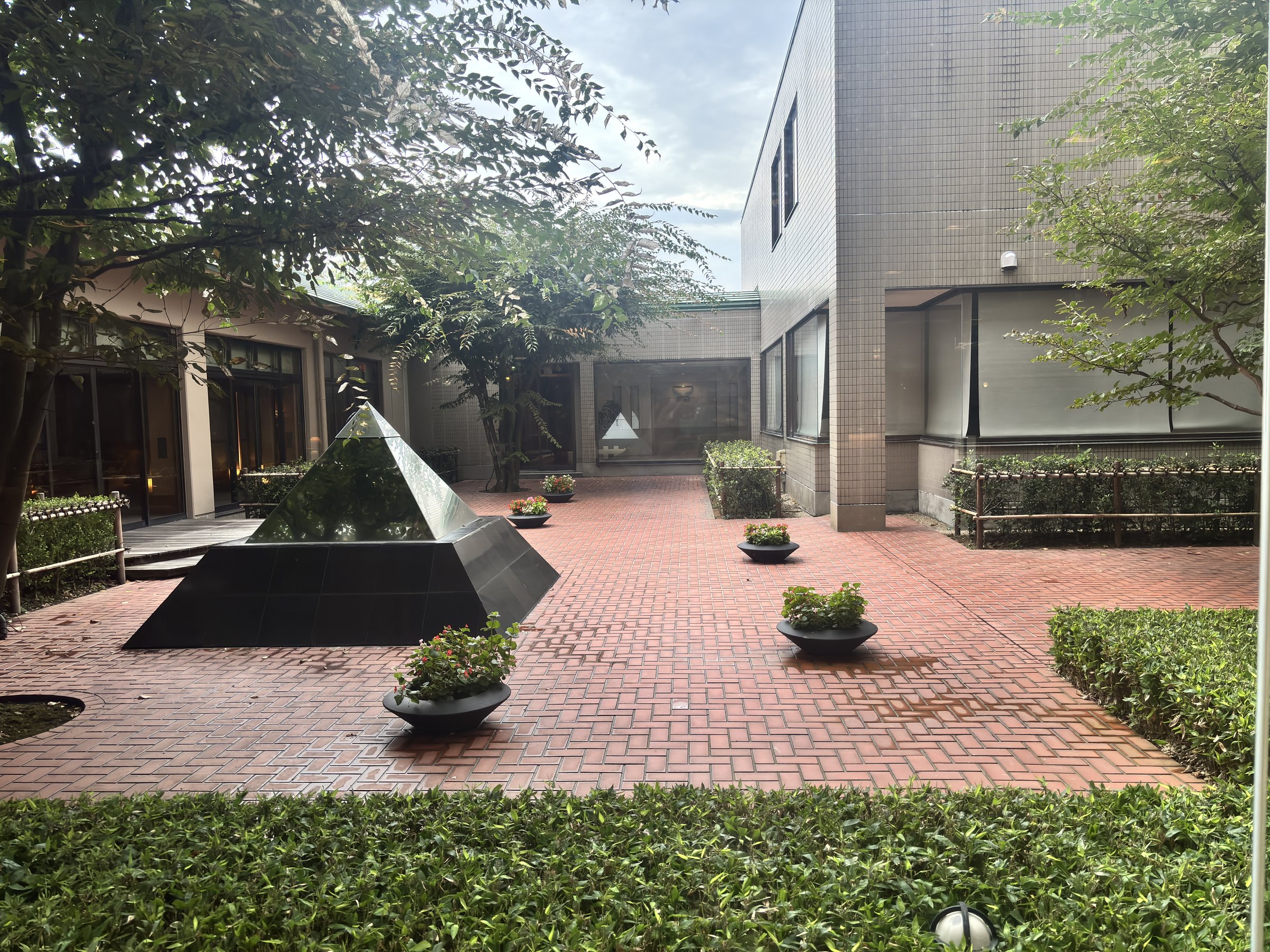 A courtyard with a stone pyramid fountain.