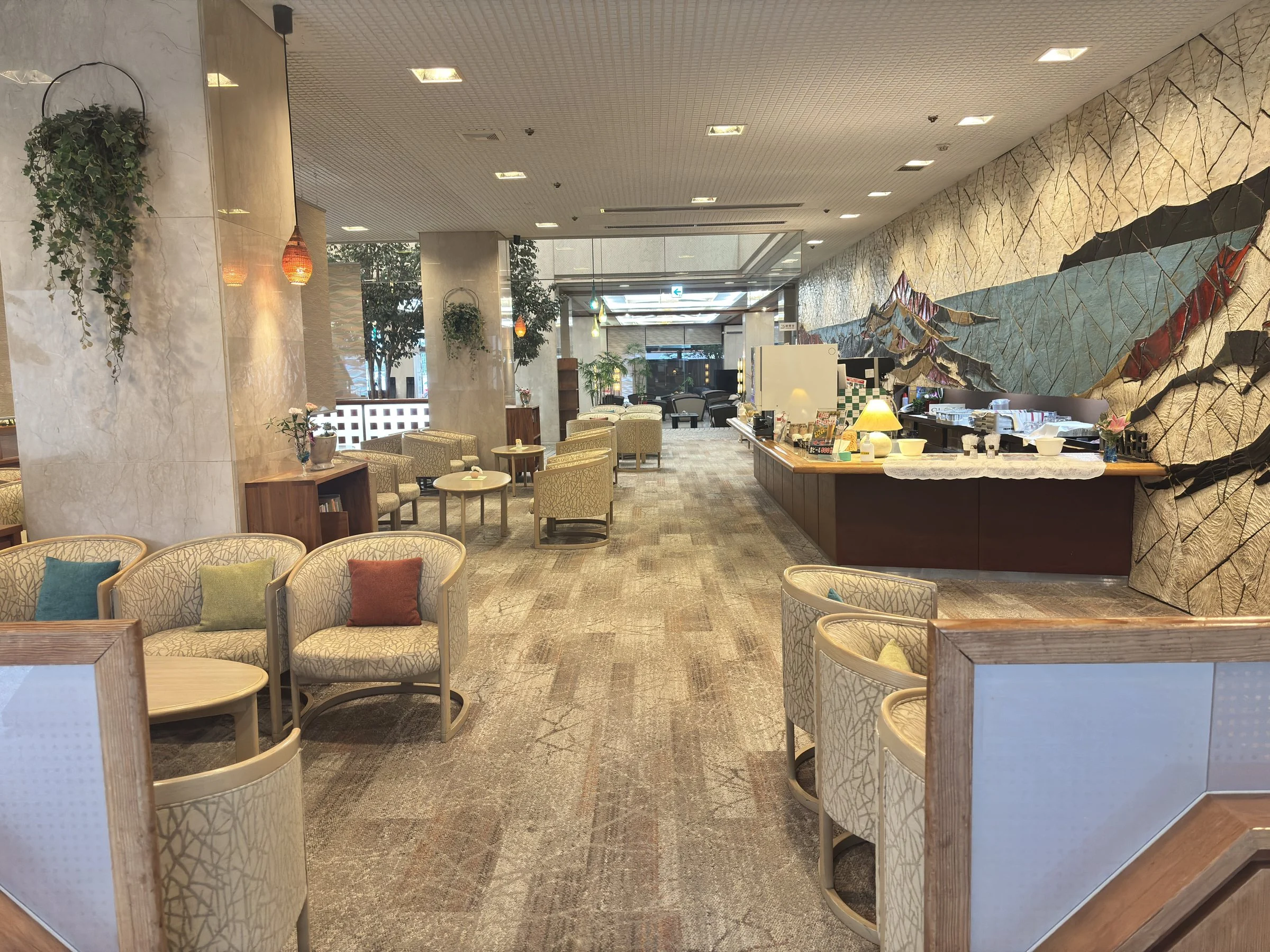 A lounge with a large mural and a buffet-style counter.