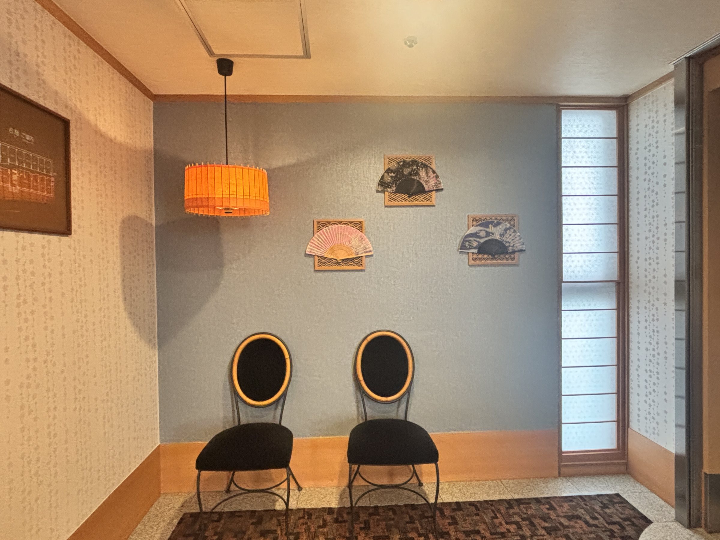 A small sitting area with two chairs and framed pictures.