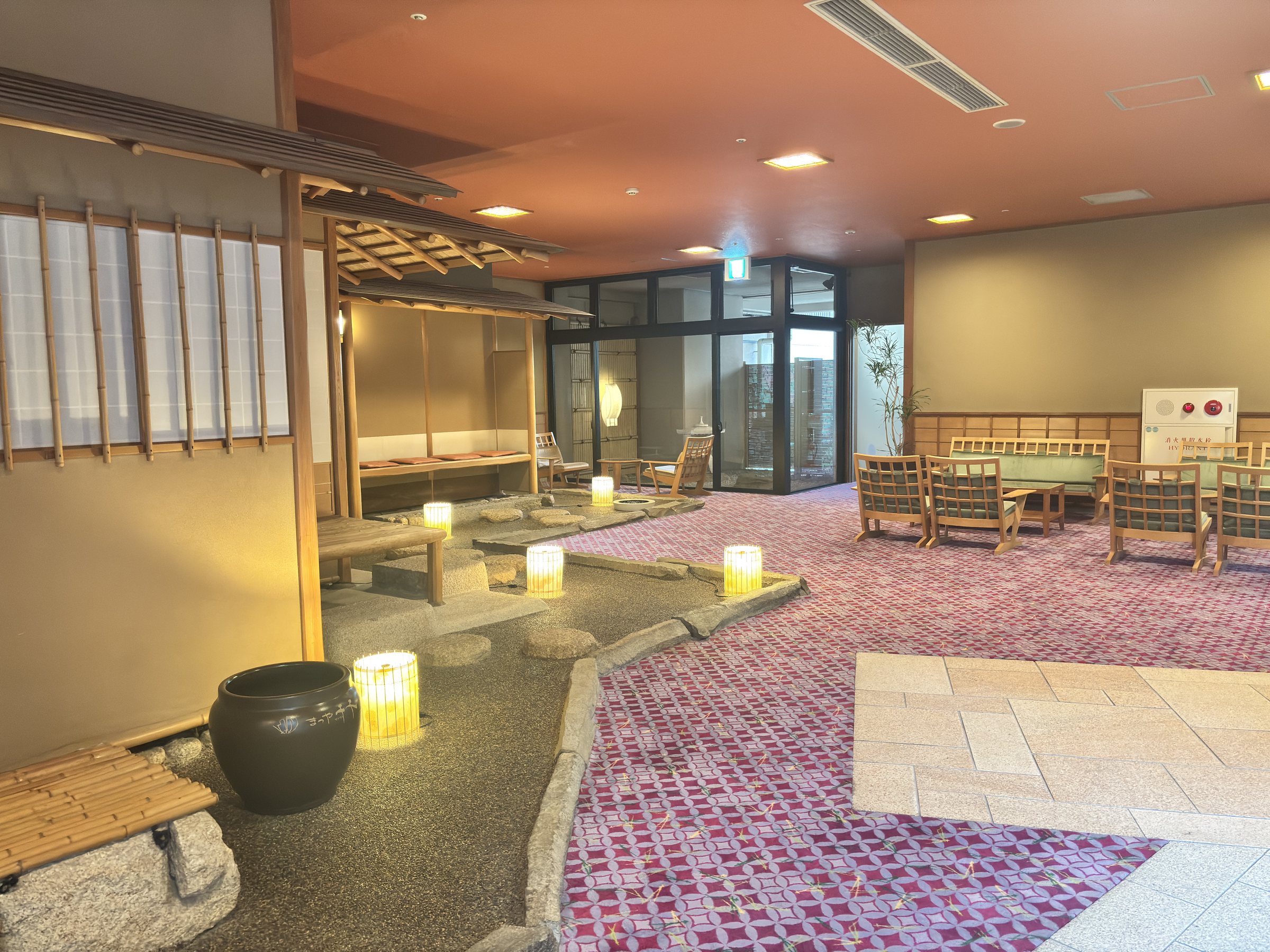 A lantern-lit indoor garden with seating.