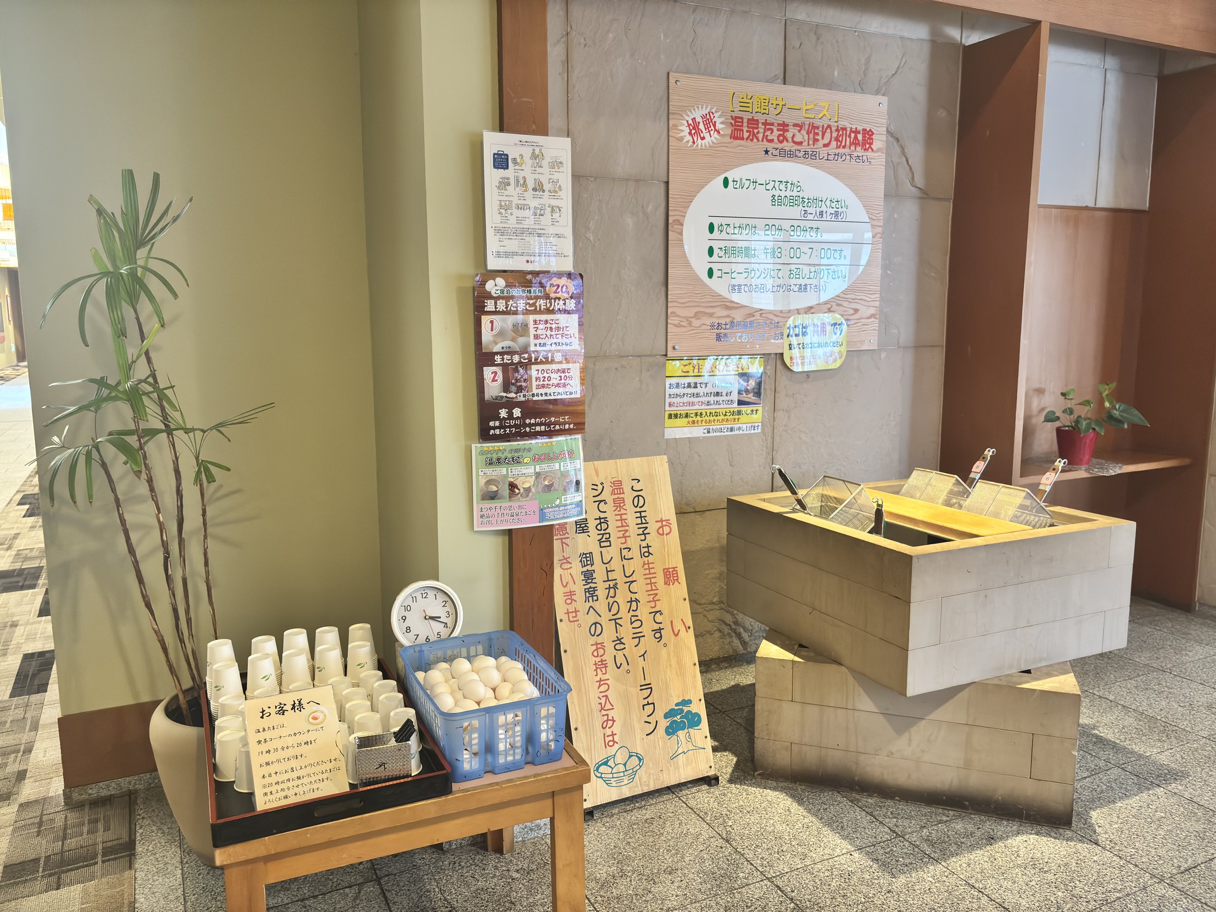 A wooden tub and notices by the onsen egg corner.