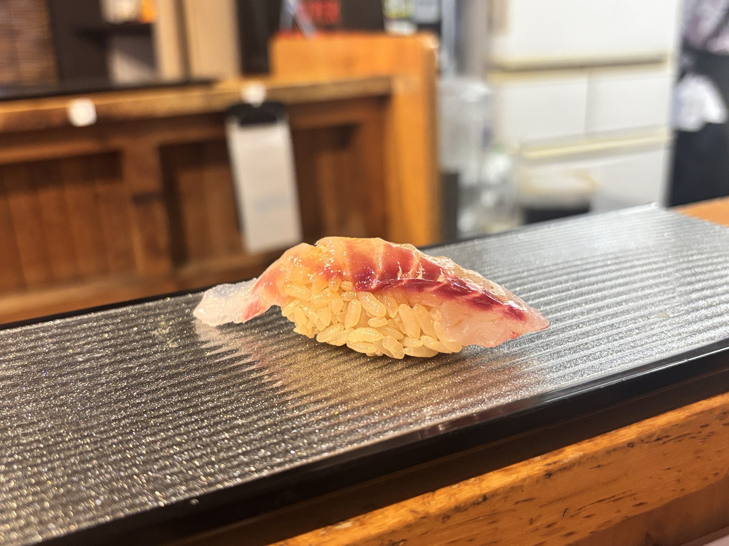 Nigiri on a glass serving board.