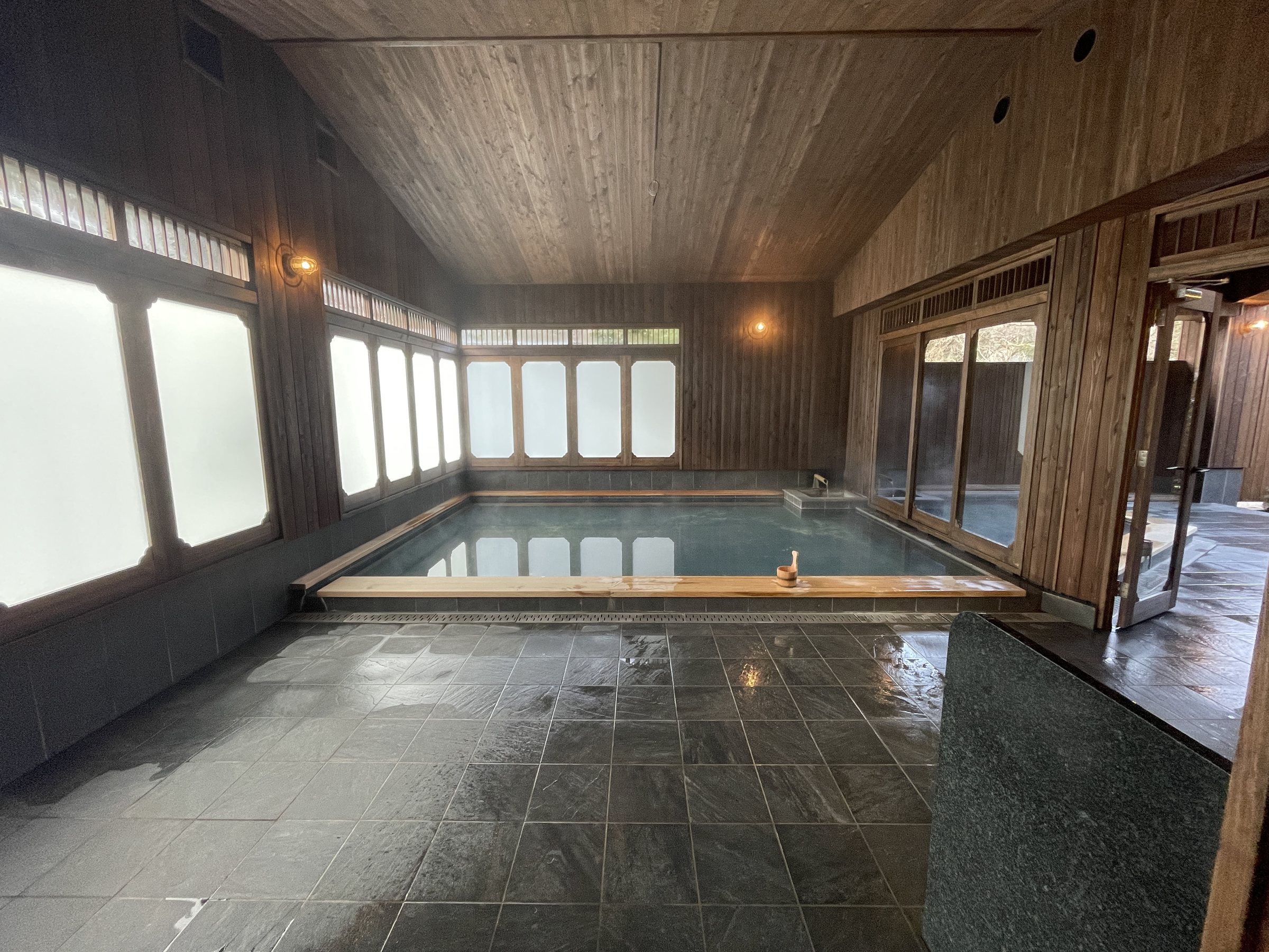 The renovated main bath: a long pool of spring water beneath a timber ceiling.