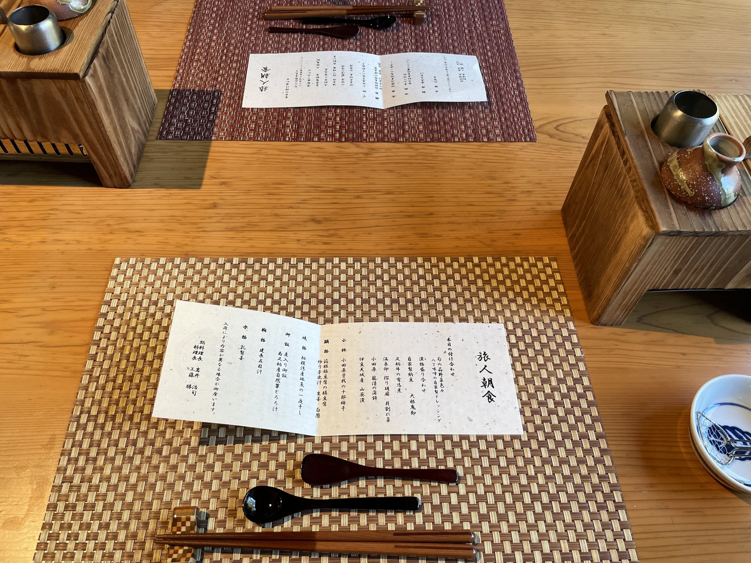 The breakfast menu, titled “Tabibito Chōshoku”, the traveler's breakfast, laid on a woven place mat.