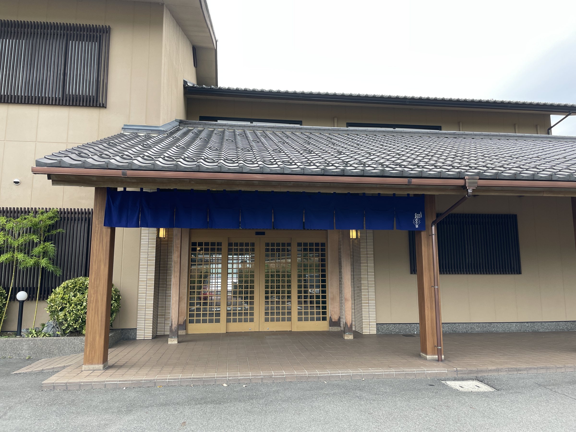 The entrance: a tiled porch and a deep indigo noren curtain.