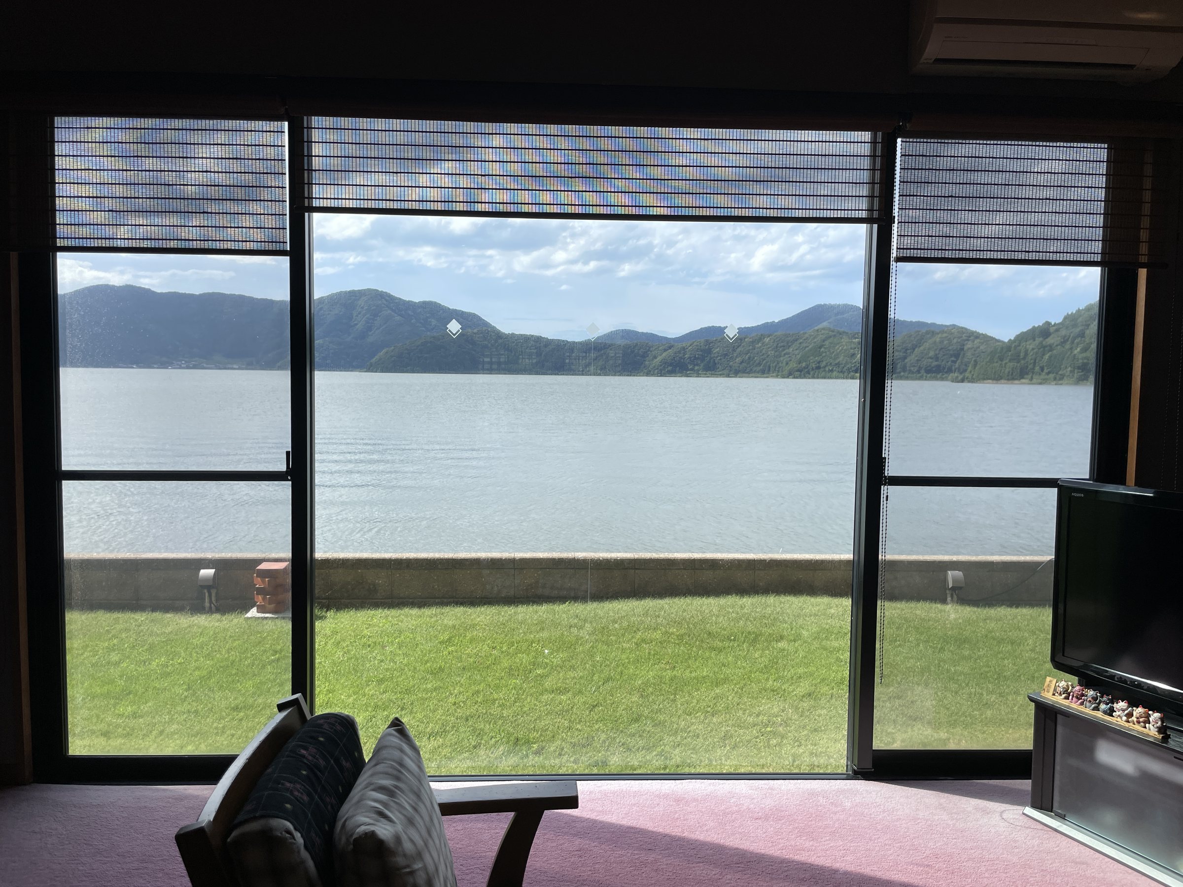 The lobby window: a lawn, the lake and the mountains beyond.