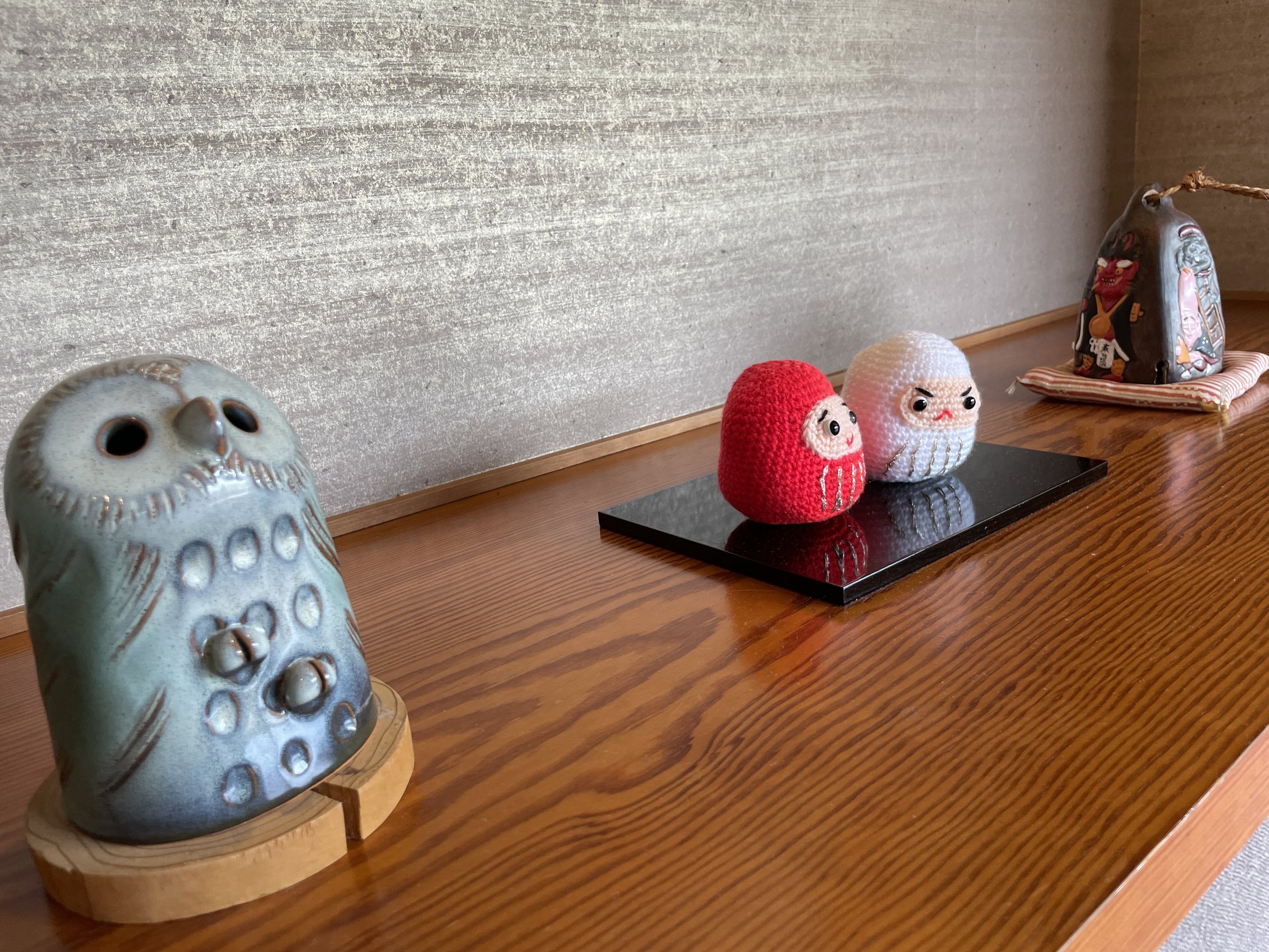 A ceramic lantern and a pair of daruma dolls on display.