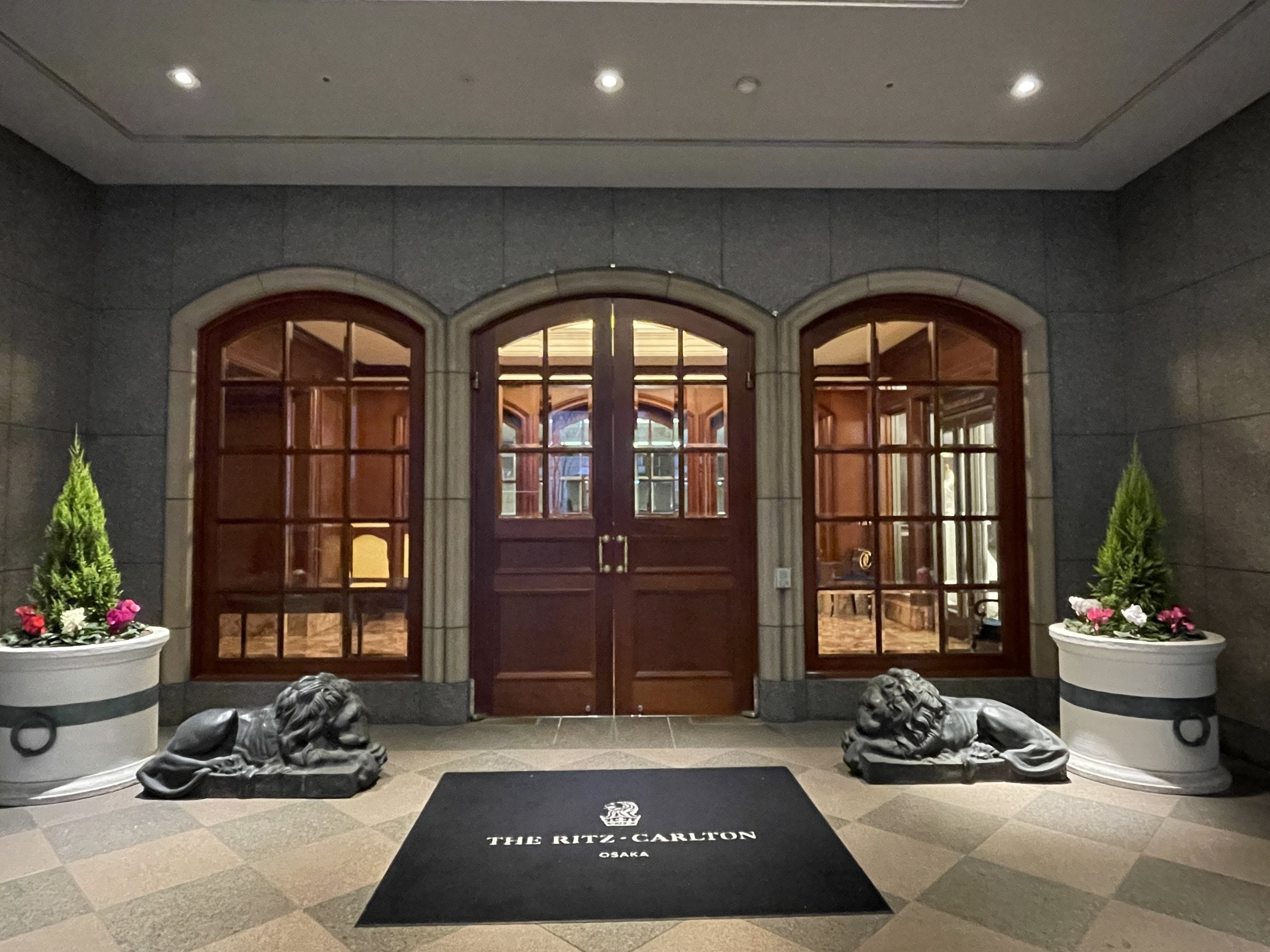 The second entrance: arched wooden doors flanked by a pair of reclining stone lions.