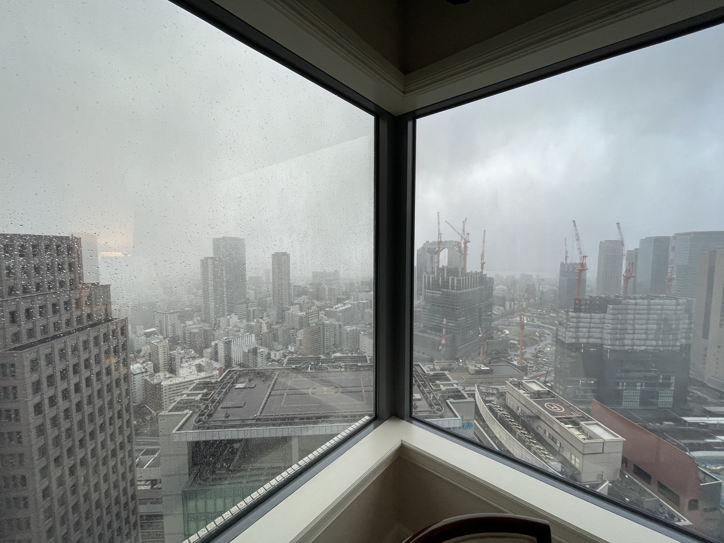 Rain over Osaka's towers from the corner window.