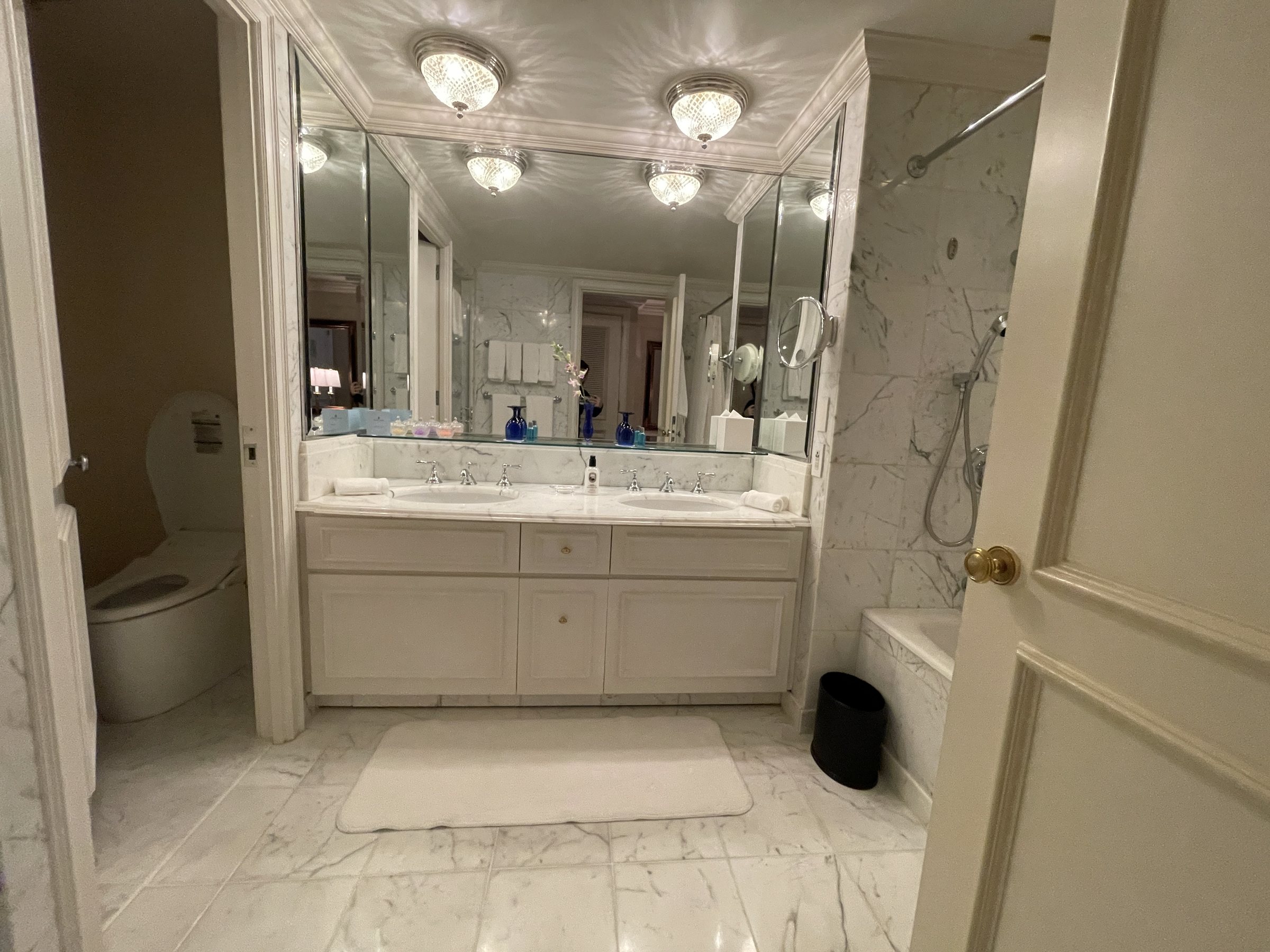 The bathroom: a long marble vanity under crystal lights.