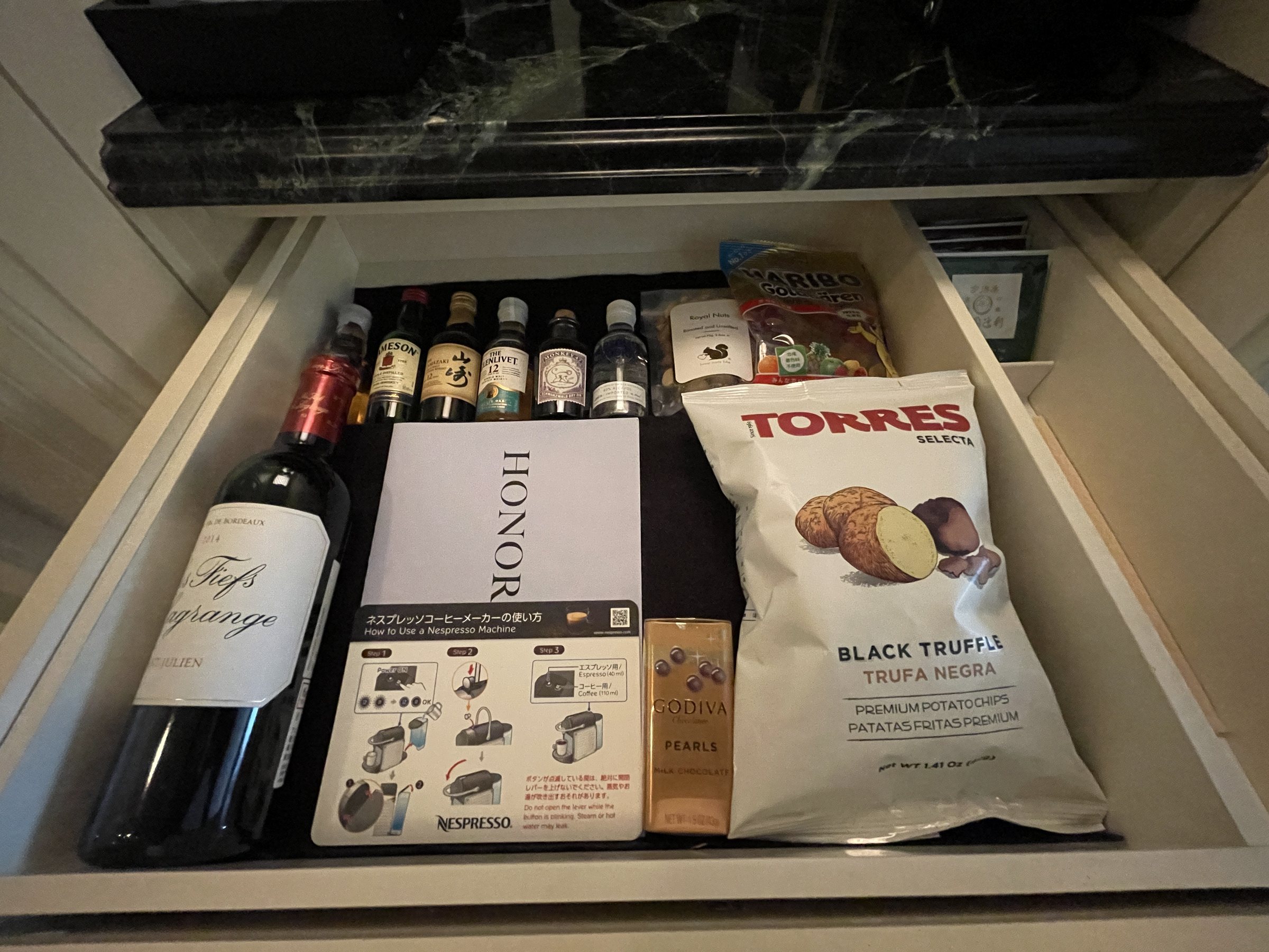 A minibar drawer of wine, spirits and snacks.