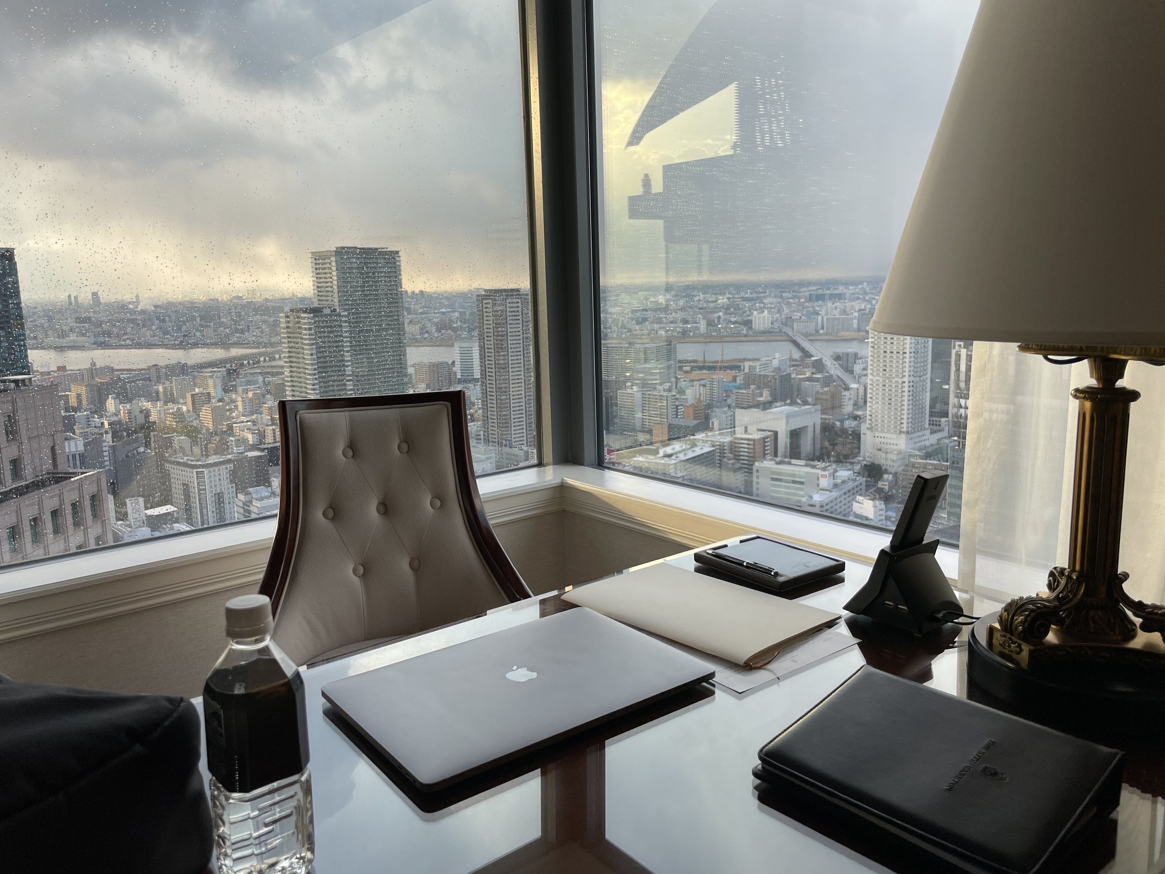 The desk by the window as the sky clears over the city.
