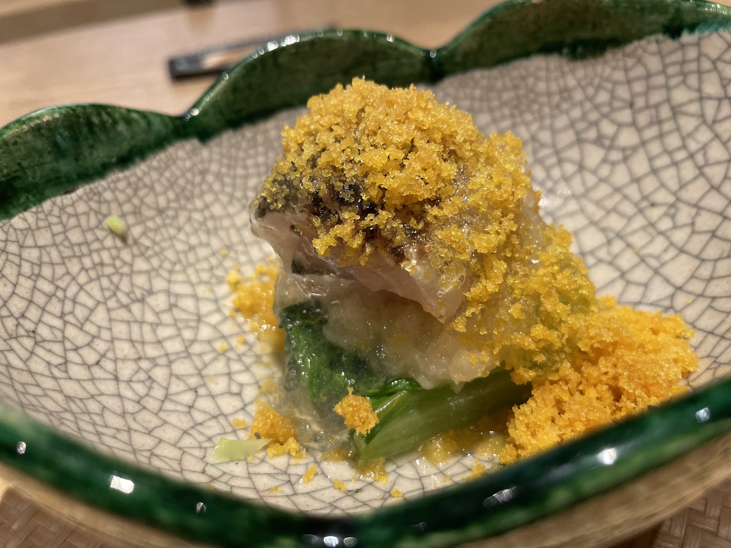 Seared cutlassfish layered with greens and grated daikon, under a thick scattering of grated bottarga.