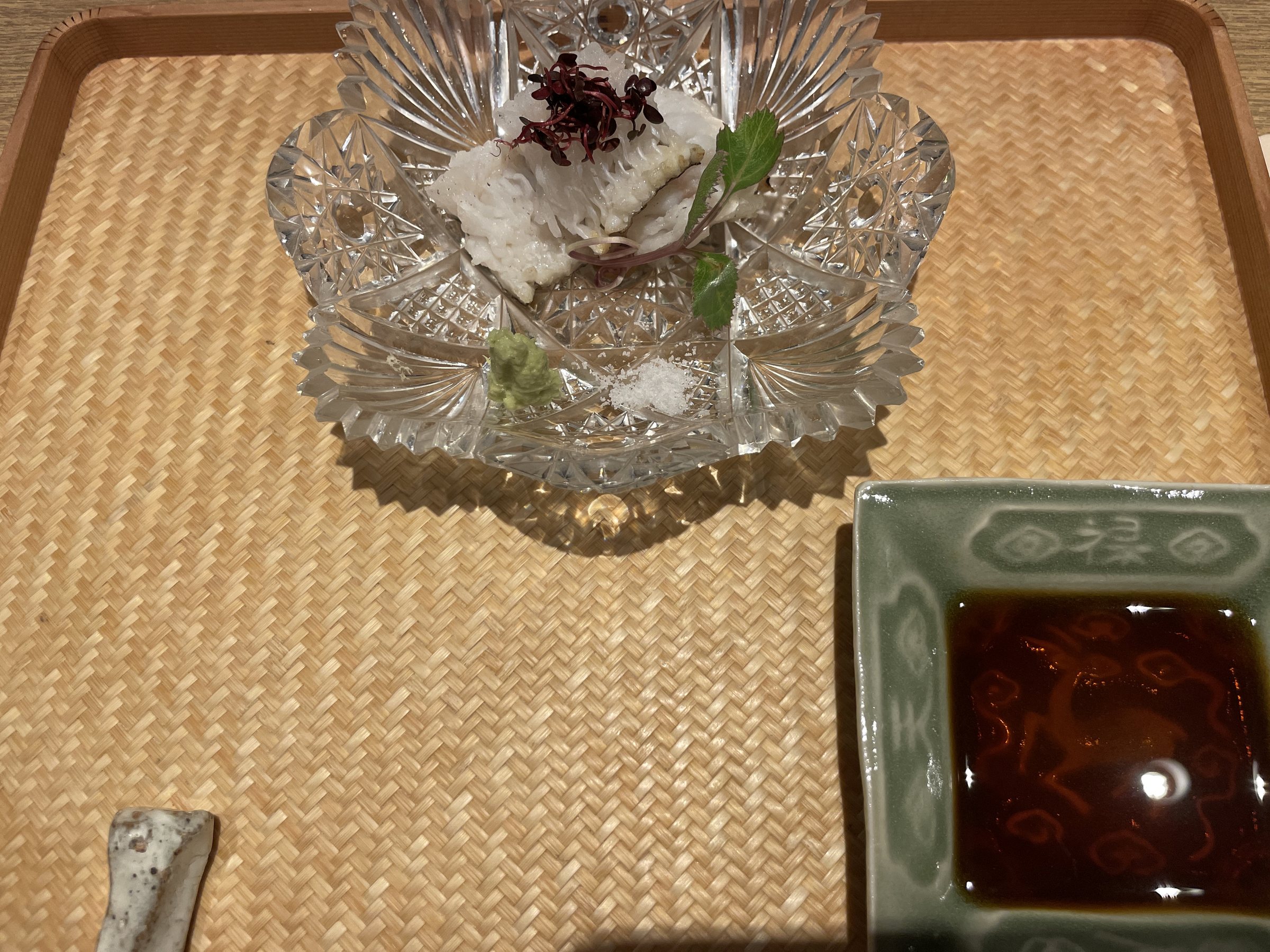 Conger eel sashimi in a cut-glass dish, with a dipping sauce alongside.