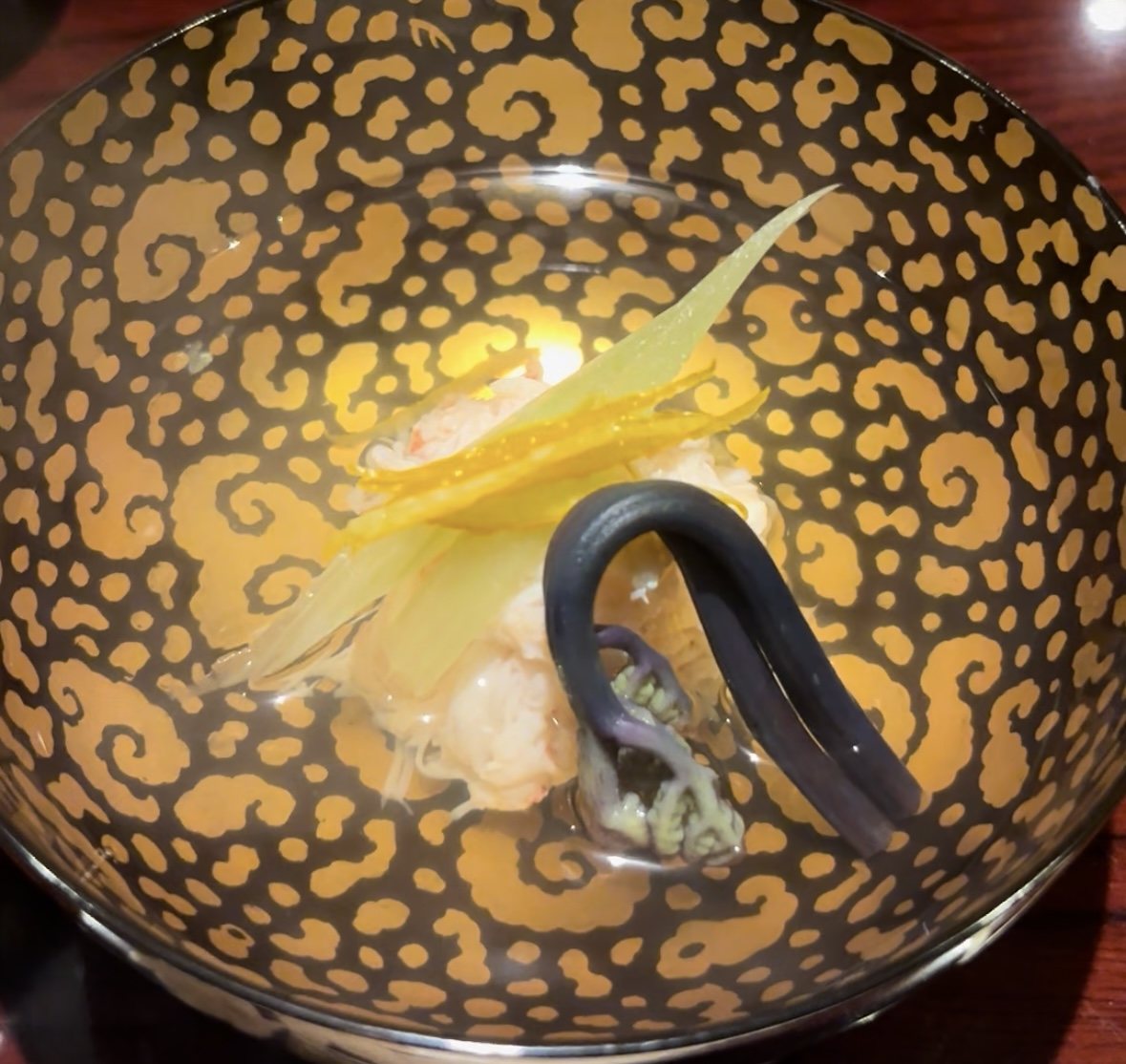 Inside the bowl: crab under slivers of vegetable and a curl of bracken.