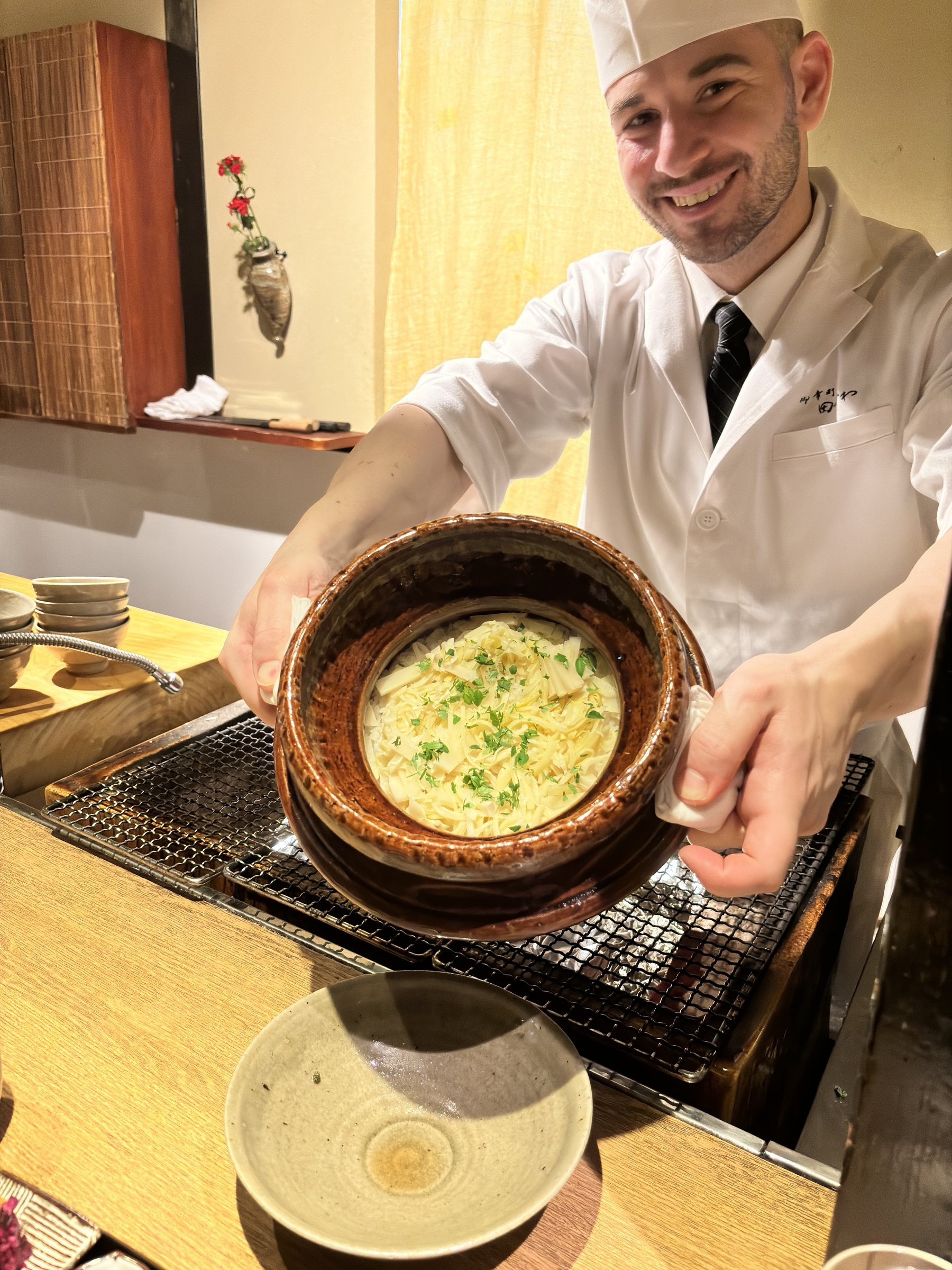 A cook presents a second pot of seasoned rice.
