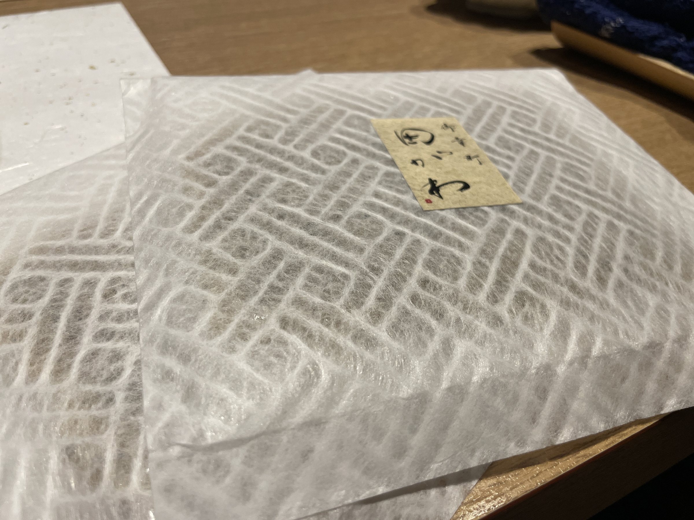 A gift wrapped in patterned white paper, labeled with the restaurant's name.