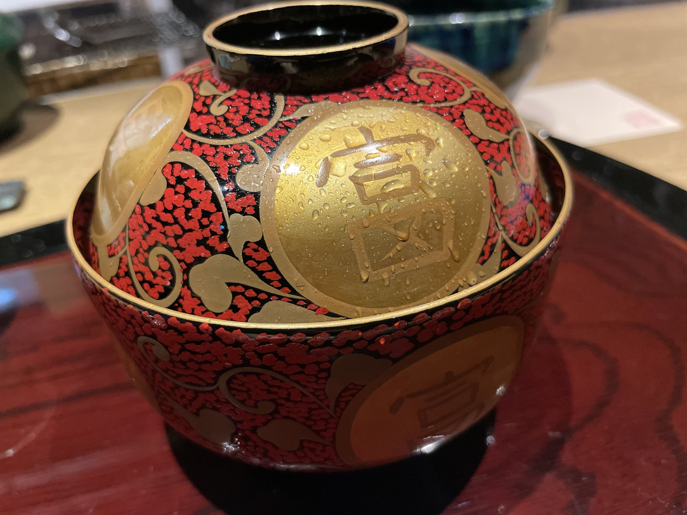 A red and gold lacquered lidded bowl.