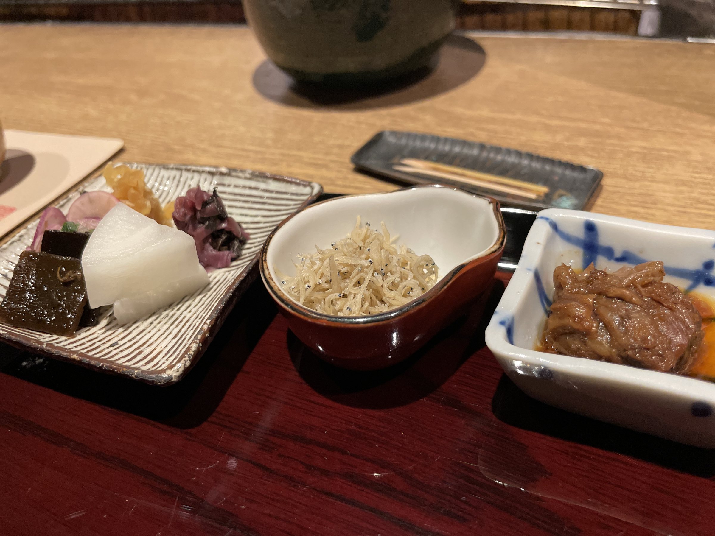 Small dishes of pickles, chirimen sansho and simmered beef sinew.