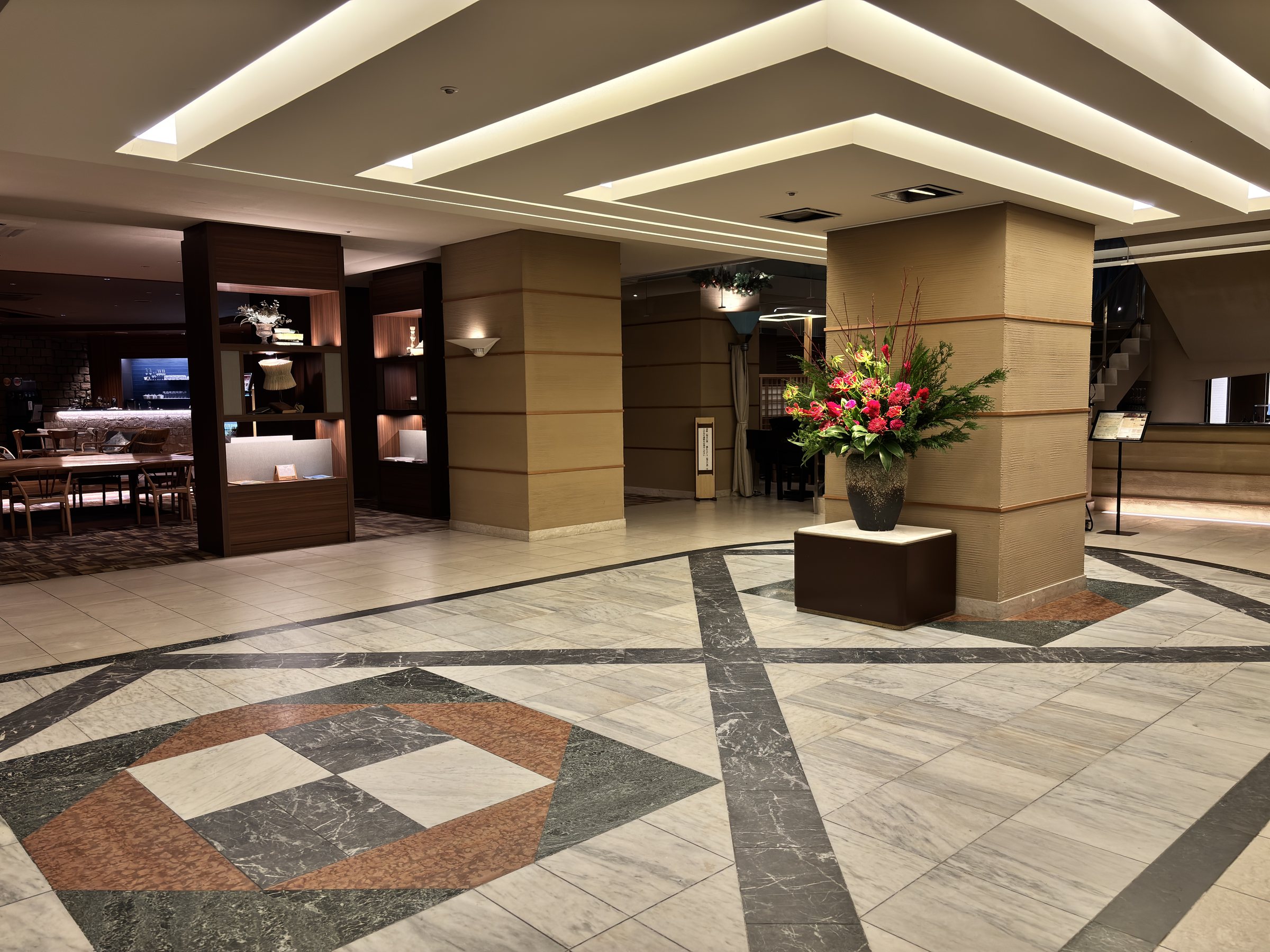 The lobby, with a marble floor and a large flower arrangement.