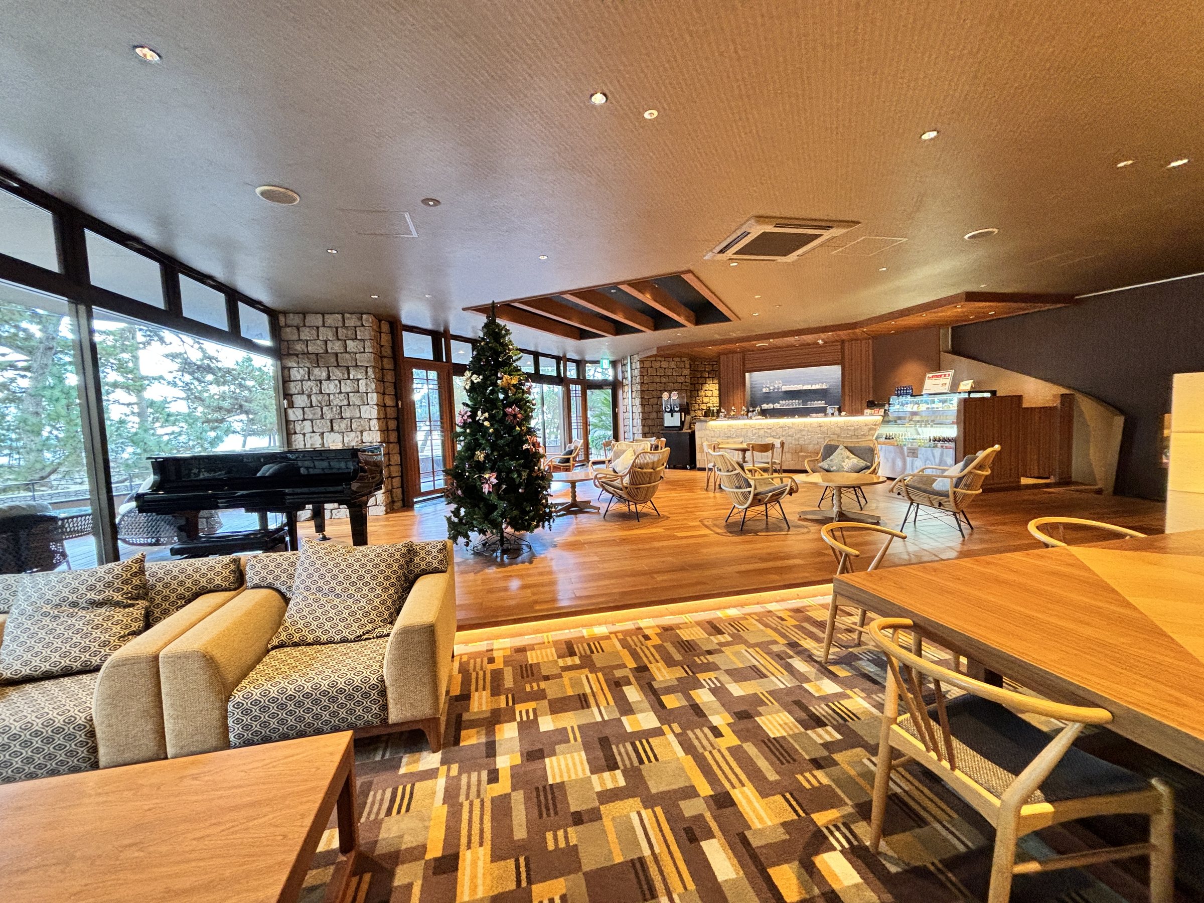 The lounge, with a grand piano and a Christmas tree.