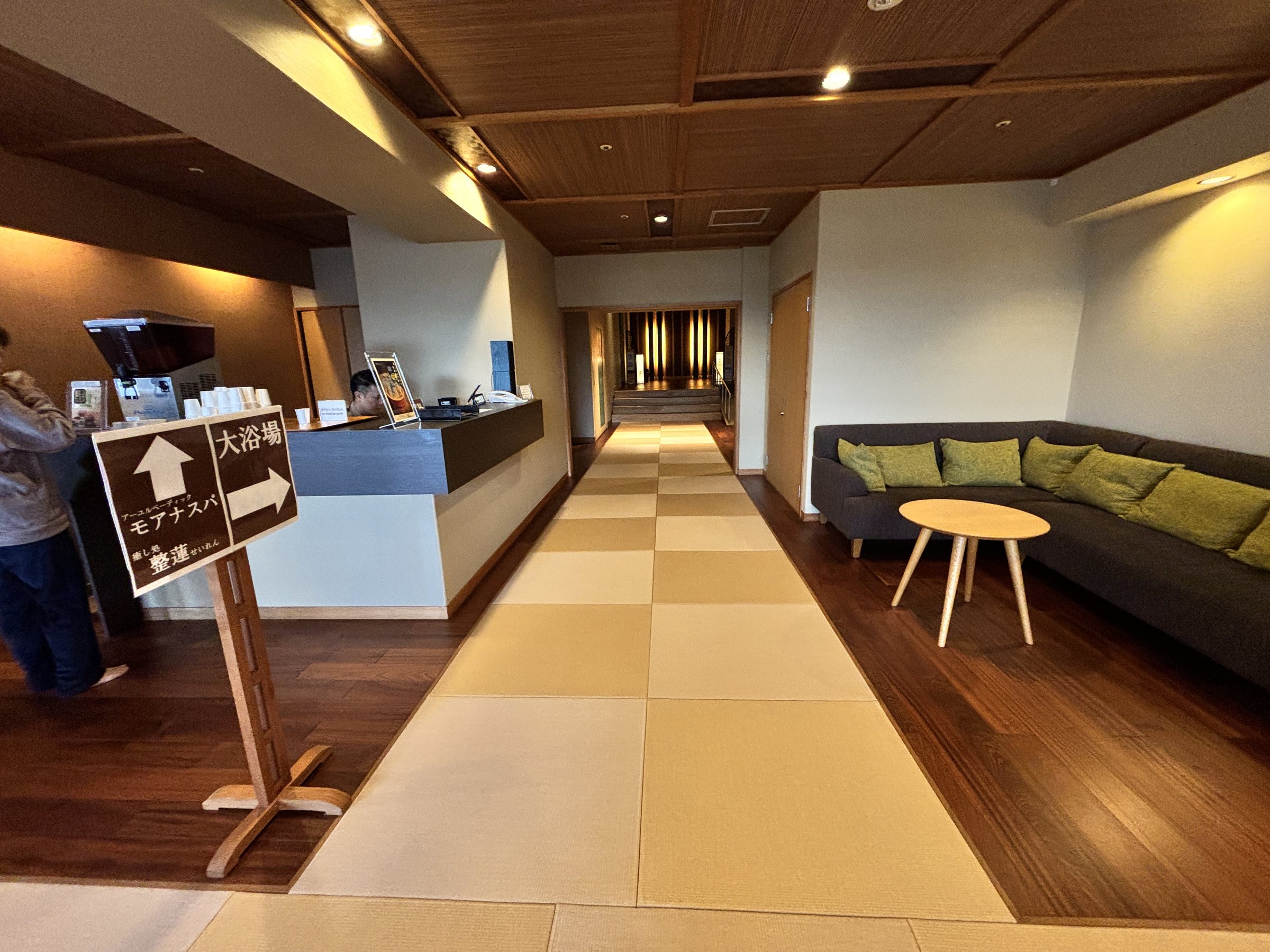 The corridor to the baths, with a sofa and sign.
