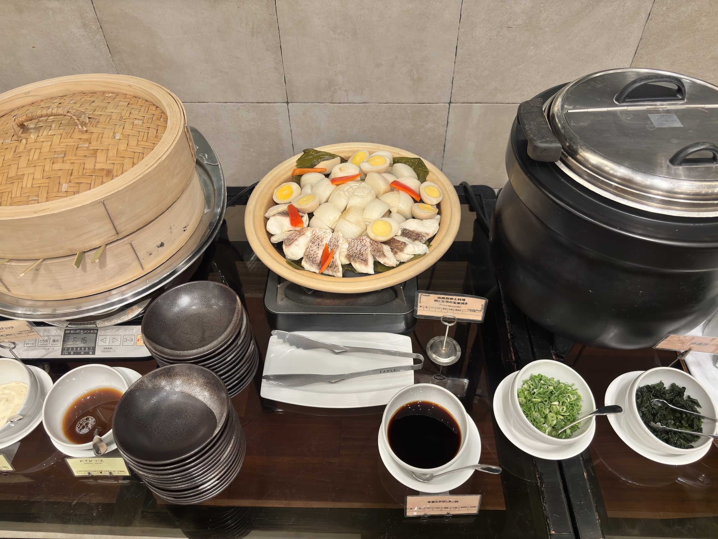 A bamboo steamer, a soup urn and condiments.