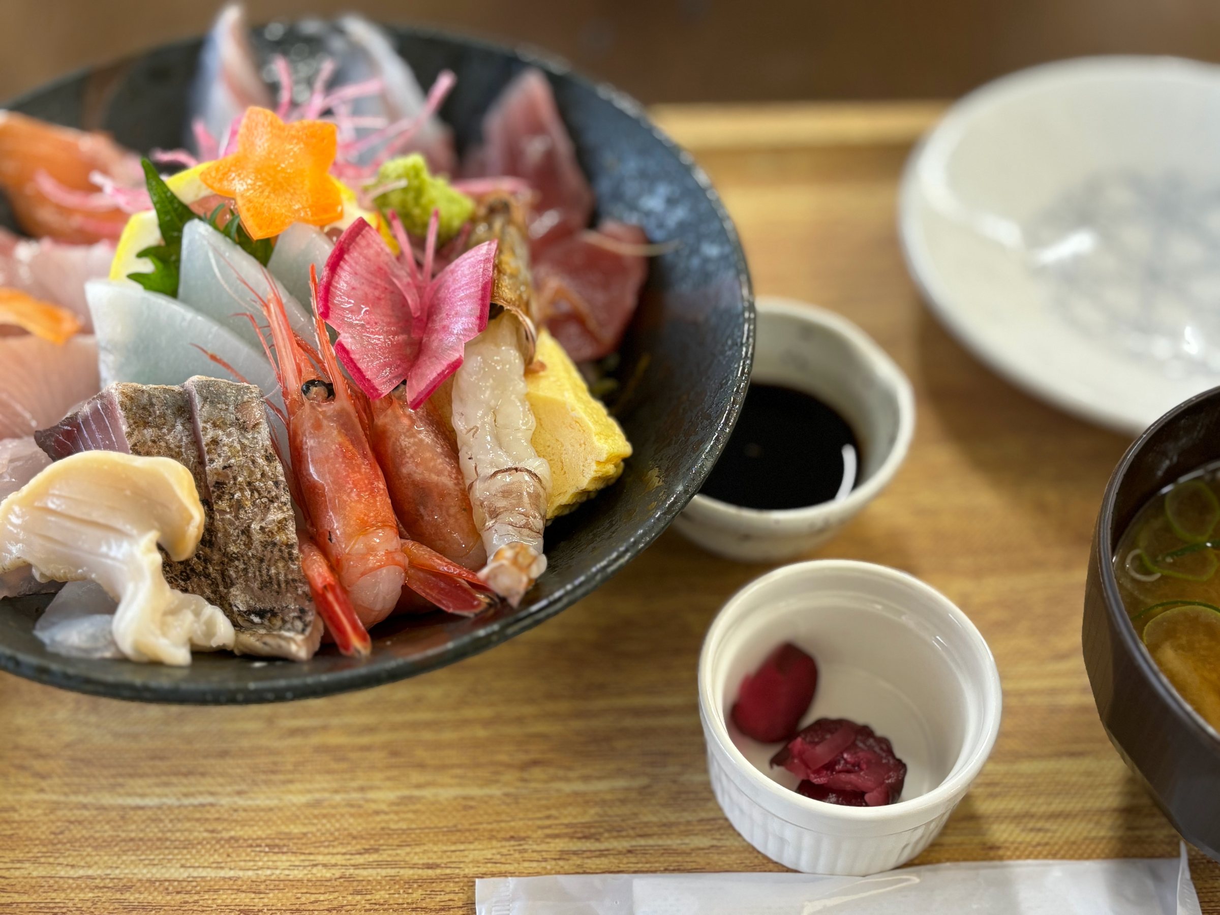 A seafood bowl at Hamasaka, piled with prawns, squid, seared and white fish.
