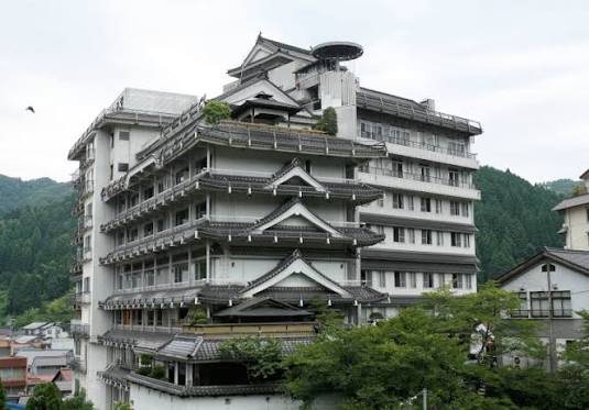 Asanoya's tiered, castle-like building against the hills of Yumura Onsen.