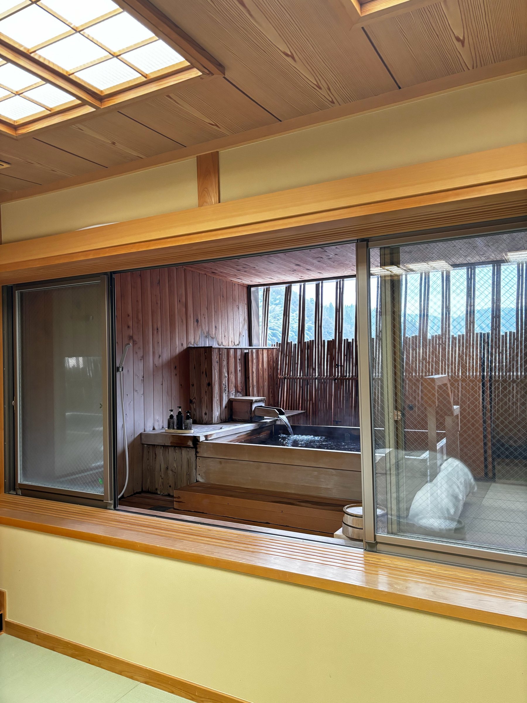 The open-air bath seen through the glass from the room.