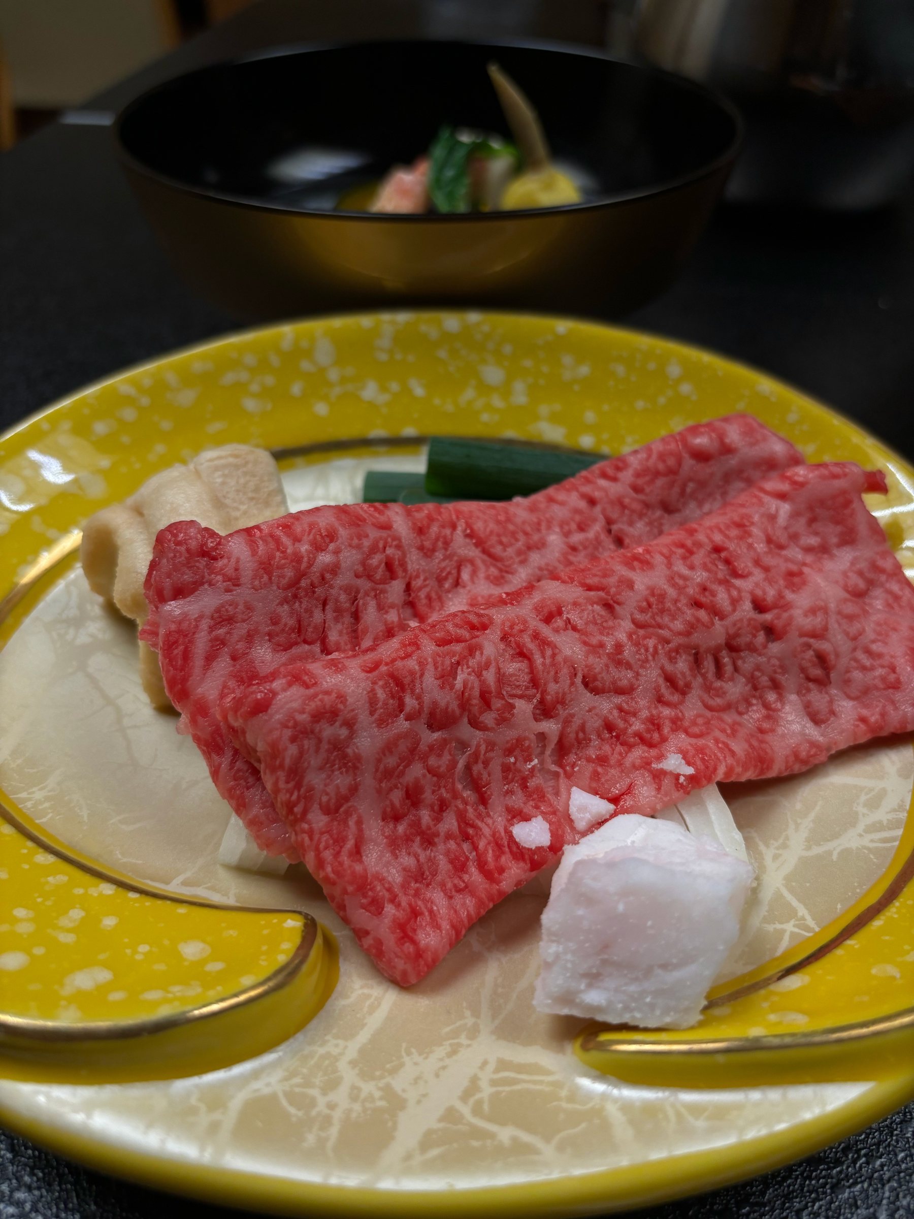 Marbled wagyu on a yellow plate, ready for the individual grill.