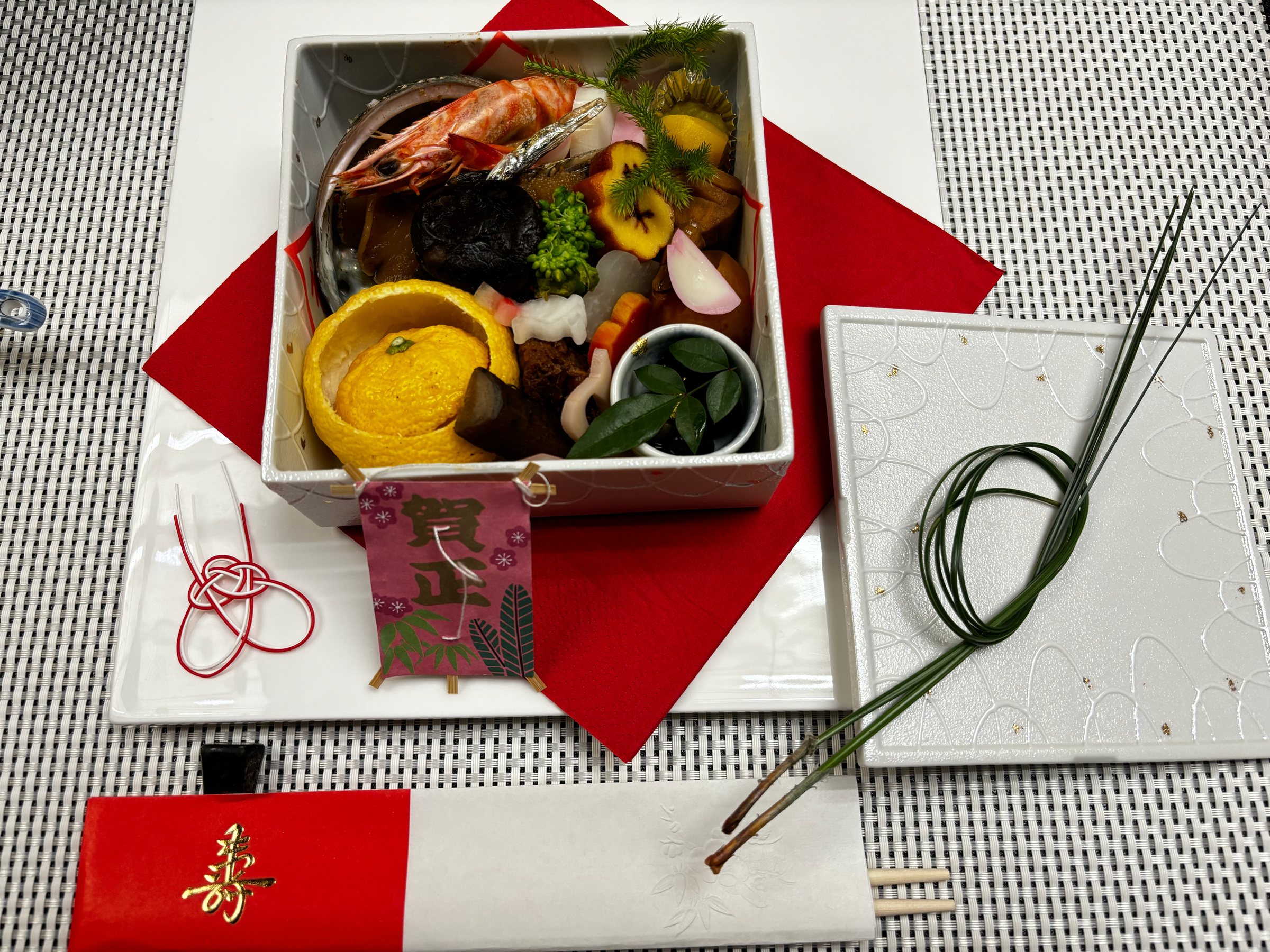 The New Year breakfast setting: the box on red and white paper, with a "Gashō" kite.
